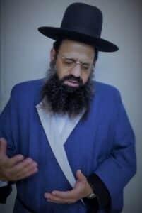 הרב-שקד-בתפילה-בעודו-עוטה-את-הגלימה-של-המקובל-האלוקי-הרב-יצחק-כדורי